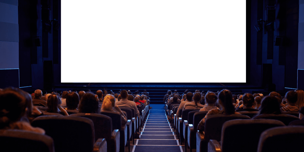 Empty cinema with an audience facing a large blank screen