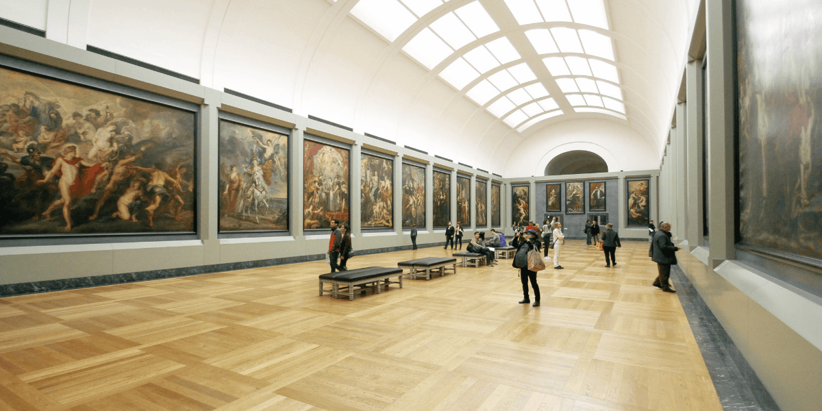 Interior of an art gallery with large paintings and visitors observing the art
