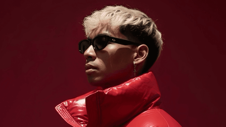 Atlas Nguyen, EDM producer, rocking a red jacket and sunglasses against a bold red backdrop.
