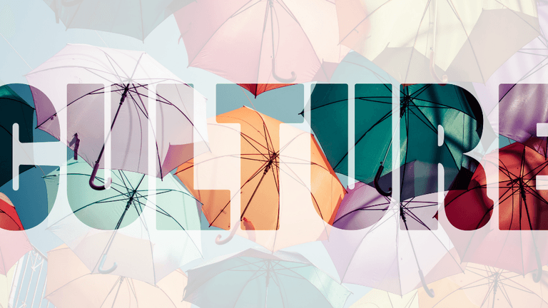 Colorful umbrellas suspended overhead with the word "CULTURE" overlaid across the image.