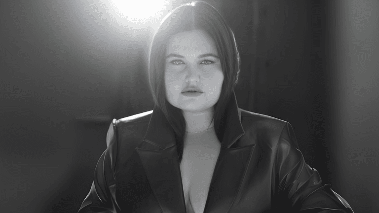ANEVIIA in dramatic lighting, wearing a dark leather jacket, symbolizing her artistic transformation and rebirth.