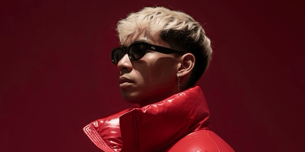 Atlas Nguyen, EDM producer, rocking a red jacket and sunglasses against a bold red backdrop.