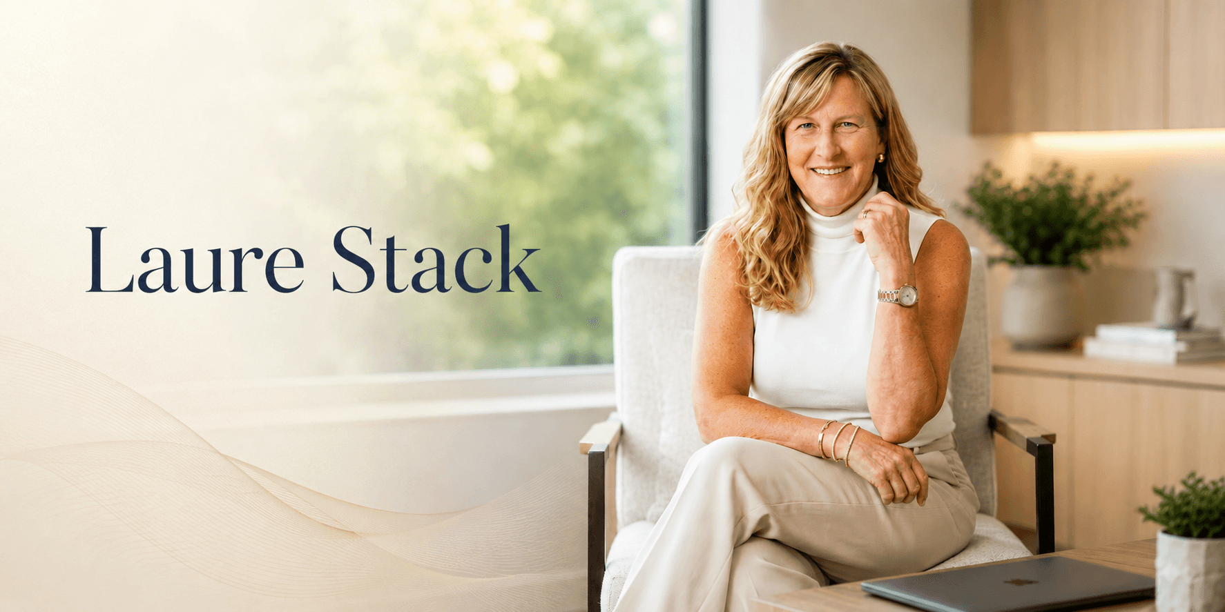Laure Stack smiling in a bright office, seated in a chair beside her name.