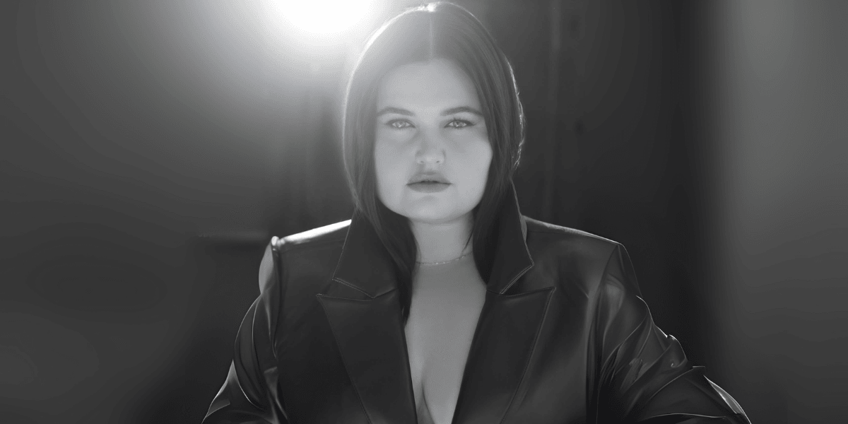 ANEVIIA in dramatic lighting, wearing a dark leather jacket, symbolizing her artistic transformation and rebirth.