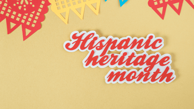 Colorful papel picado decorations with the text Hispanic heritage month on a yellow background