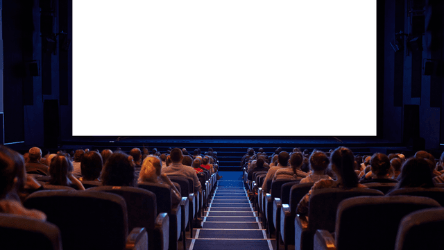Empty cinema with an audience facing a large blank screen
