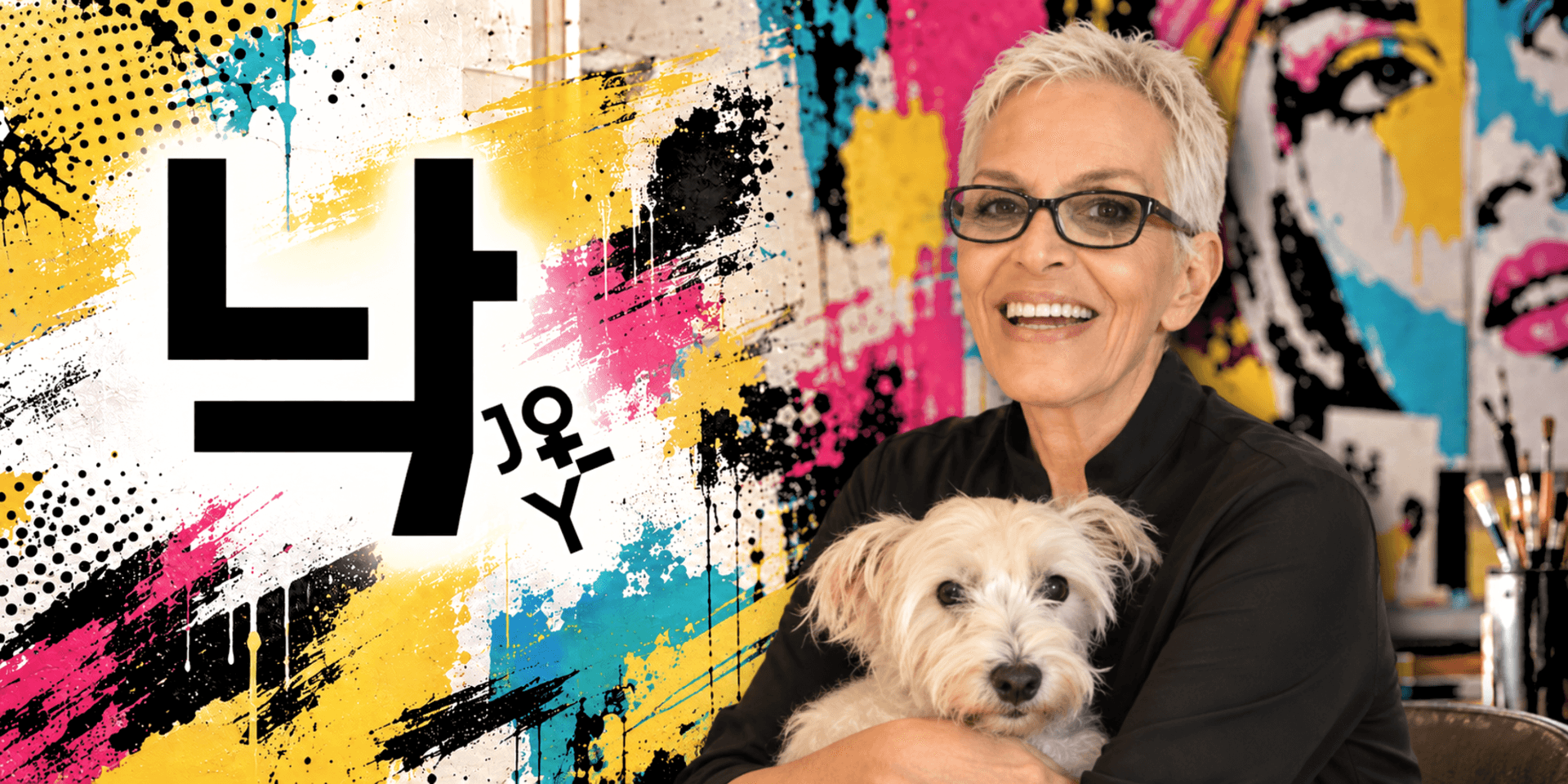 Smiling woman with short gray hair holds a dog against a colorful graffiti background