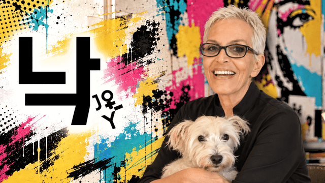 Smiling woman with short gray hair holds a dog against a colorful graffiti background